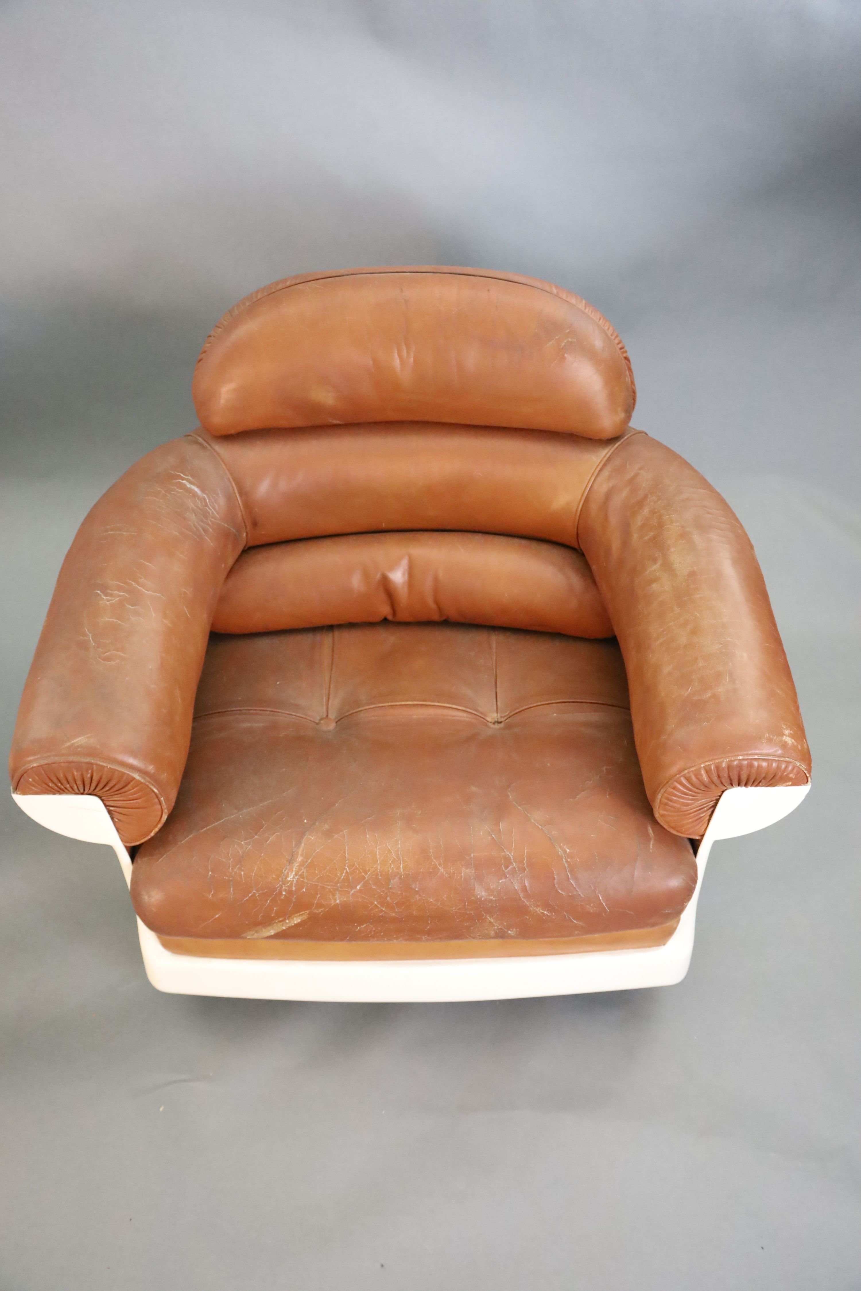 A pair of mid century tan leather and fibreglass tub chairs, possibly French, by Airbourne, width 90cm, depth 75cm, height 78cm